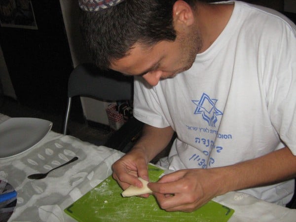 Gab preparing Shavuot cheese pastelles by folding them